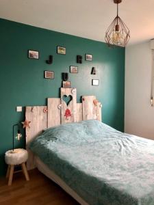 MontmorotLes Salines的一间卧室设有一张床和绿色的墙壁