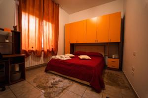 佩斯卡拉Sole Luna B&B的一间卧室配有一张带红色床单和橙色橱柜的床。