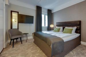 延雪平克莱里昂珍藏维多利亚酒店的一间卧室配有一张床、一把椅子和电视