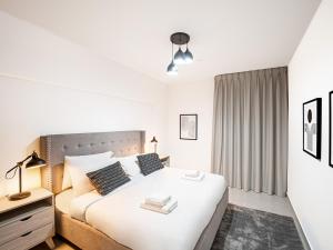 迪拜Soft touch & Spacious 2 Bed next to Metro的白色的卧室设有一张大床和一个窗户