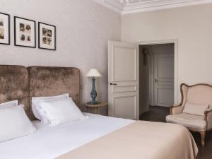 巴黎New Hotel Roblin的卧室配有一张白色大床和一把椅子