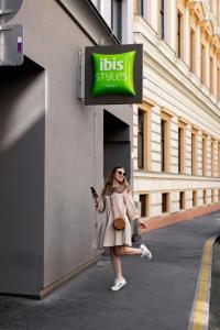 维也纳ibis Styles Wien Messe Prater的女人站在公共厕所外