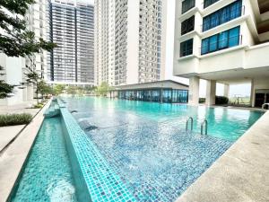实达阿南E 1-5Pax Cozy home 4 Bed Wifi TV Trefoil @Setia City Setia Alam SCCC的一座高楼建筑中的大型游泳池