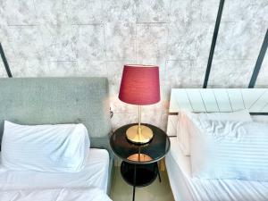 实达阿南E 1-5Pax Cozy home 4 Bed Wifi TV Trefoil @Setia City Setia Alam SCCC的一张桌子上的红灯,旁边是两张床
