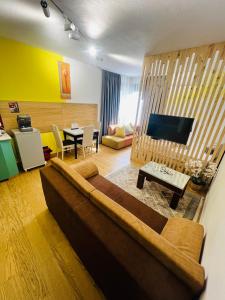 都拉斯Colombia Apartments&Rooms的带沙发的客厅和用餐室