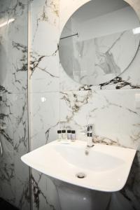克利默内什蒂Astra Hotel的浴室设有白色水槽和镜子