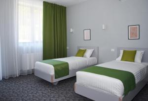 克利默内什蒂Astra Hotel的绿白色客房内的两张床