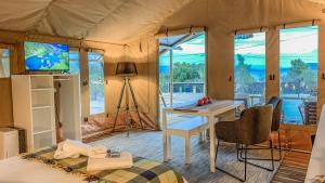 克兰尼蒂African Safari Canvas Lodge Tent Sea View的帐篷内带一张床和一张书桌的房间