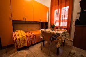 佩斯卡拉Sole Luna B&B的一间卧室配有一张桌子和一张带橙色橱柜的床。