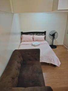 锡朗Monteluce Condominium的一间卧室配有一张带棕色沙发的床