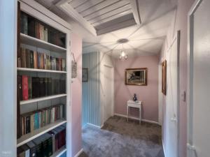 蒙默思Charming cottage within farmhouse的走廊上设有书架和桌子