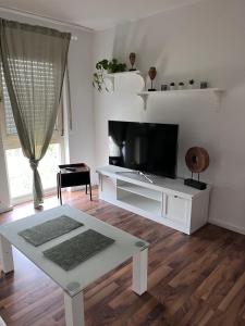 施韦青根Good living的客厅配有电视和白色桌子。
