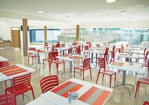 ItuiutabaBernal Hotel Econômico的一间摆放着桌子和红色椅子的房间