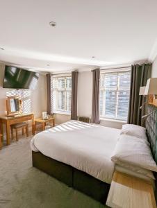伯恩茅斯名流酒店（原品质伯恩茅斯酒店）的一间卧室配有一张大床和一台平面电视