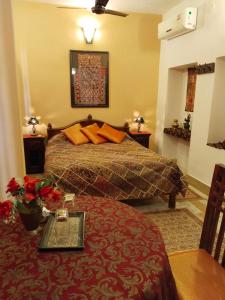 斋沙默尔齐拉巴哈旺旅馆的配有床和鲜花桌的酒店客房