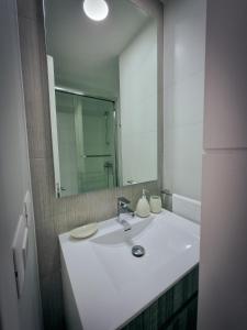 维纳德马Exclusivo Departamento a Pasos de la Playa en Viña的浴室设有白色水槽和镜子