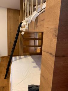 圣维吉利奥Ciasa Ciaccio的木墙客房的一张高架床