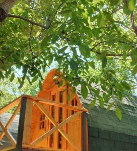 TalaganteCabañas Peñaflor Glamping的树下有木门的橙色建筑
