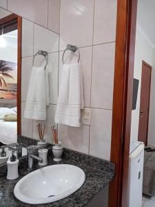 瓜鲁雅Refúgio BEM-TE-VI的浴室配有盥洗盆、镜子和毛巾