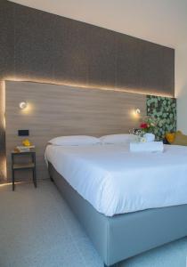 古比奥Hub Hotel的卧室配有一张白色大床和床头板