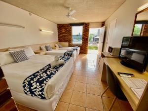 黄金海岸卡姆登汽车旅馆的客厅配有两张床和一台平面电视