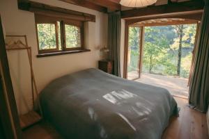 Castelnau-de-MandaillesLake House I // Alauzet Ecolodge + Nature spa的一间卧室设有一张床和一个大窗户