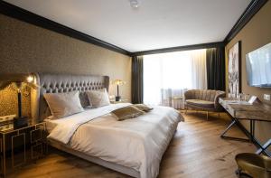 弗罗伊登施塔特Waldhotel Luise的酒店客房设有一张大床和一张书桌。