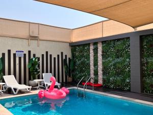 拉斯阿尔卡麦Pool Villa Saraya的中间有一个粉红色充气天鹅的游泳池