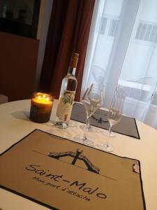 圣马洛Le Plongeoir, intra-muros的一张桌子,上面放着一瓶葡萄酒和两杯酒