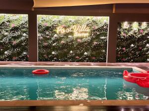 拉斯阿尔卡麦Pool Villa Saraya的花园前的游泳池,有两只红飞盘