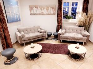 韦斯特兰叙尔特岛布劳姆谢酒店的客厅配有两张沙发和两张桌子