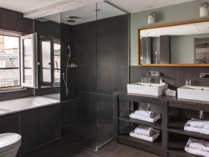 巴黎New Hotel Roblin的浴室设有2个水槽、浴缸和镜子