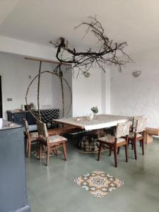 西姆拉Seclude Shimla, Taraview的一间配备有桌子和一些椅子、一张桌子及蚊帐的用餐室