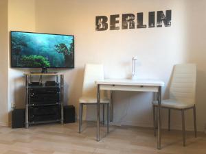 柏林"IDEAL" - für Zwei的一间配备有桌子和两把椅子及一台电视的房间