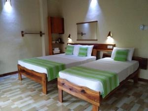 代尼耶耶Sinharaja Kurulu Ella Eco Resort的一间卧室配有两张带绿色和白色床单的床