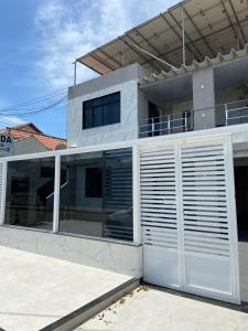 坎普斯戈伊塔卡济斯Pousada Pinheiro的白色的房子,有白色的车库门