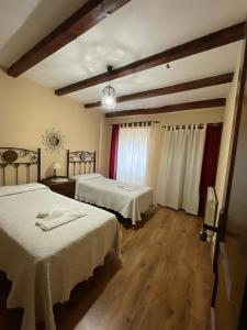 Siete Iglesias de TrabancosCasa Rural Calderon de Medina I y II的酒店客房设有两张床和窗户。
