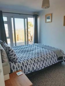 布里克瑟姆The Getaway - Modern 2 Bedroom Brixham Bungalow with sea peeps的一间卧室设有一张床和一个大窗户