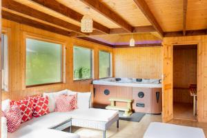 格拉斯哥Stunning 4 bedroom country house - Hot Tub & Sauna的带沙发和热水浴池的客厅