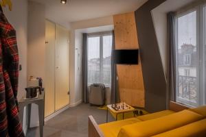 巴黎城市露营酒店的客厅设有黄色的沙发和窗户。