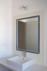 滨海拉库阿尔德Les Maisons de l'Olivette的浴室设有白色水槽和镜子