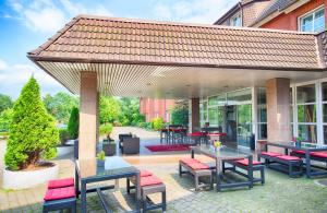 汉堡莱昂纳多汉堡斯特尔红酒店的一个带桌椅的庭院和屋顶。