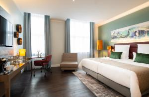 柏林柏林亚历山大广场莱昂纳多皇家酒店的一间卧室配有一张大床、一张桌子和一张书桌