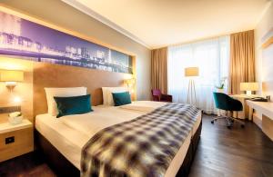 杜塞尔多夫杜塞尔多夫国王大道莱昂纳多皇家酒店的酒店客房设有一张大床和一张书桌。
