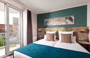 慕尼黑慕尼黑市奥林匹克公园莱昂纳多酒店的一间卧室设有一张大床和一个大窗户