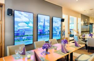 拉廷根莱昂纳多杜塞尔多夫机场拉廷根酒店的餐厅设有桌椅和大窗户。