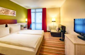 慕尼黑慕尼黑莱昂纳多酒店的配有一张床和一台平面电视的酒店客房