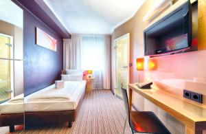 慕尼黑慕尼黑莱昂纳多精品酒店的配有一张床和一台平面电视的酒店客房
