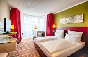 慕尼黑慕尼黑莱昂纳多酒店的酒店客房设有一张大床和一台电视。