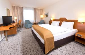 海德堡海德堡莱昂纳多酒店的酒店客房配有一张床、一张书桌和一台电视。